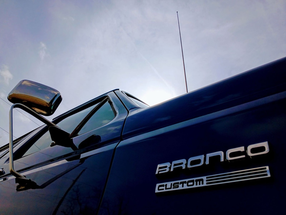 Bronco Custom badge and mirror against the sky