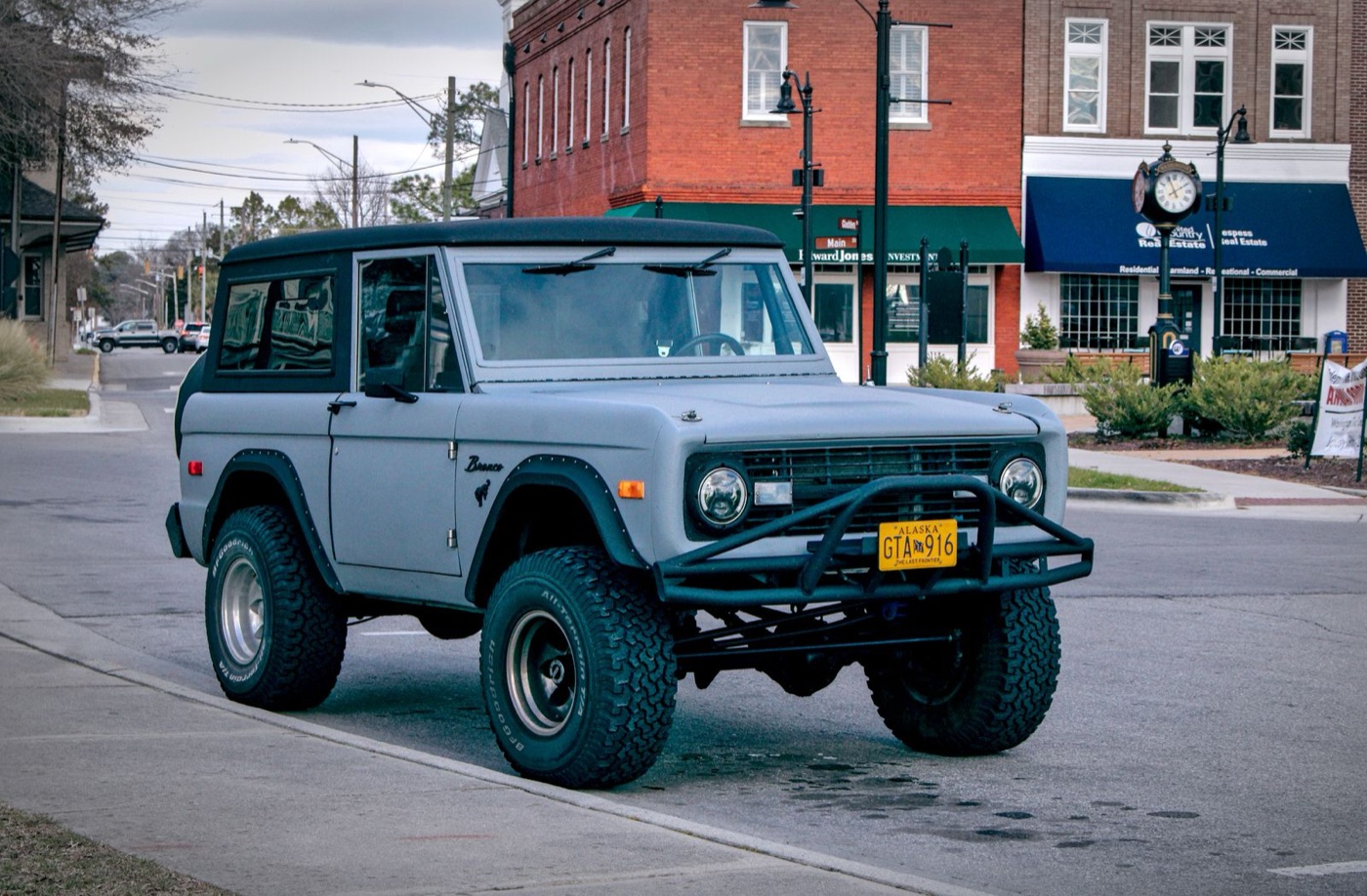 Gray first-generation Bronco on a small-town street